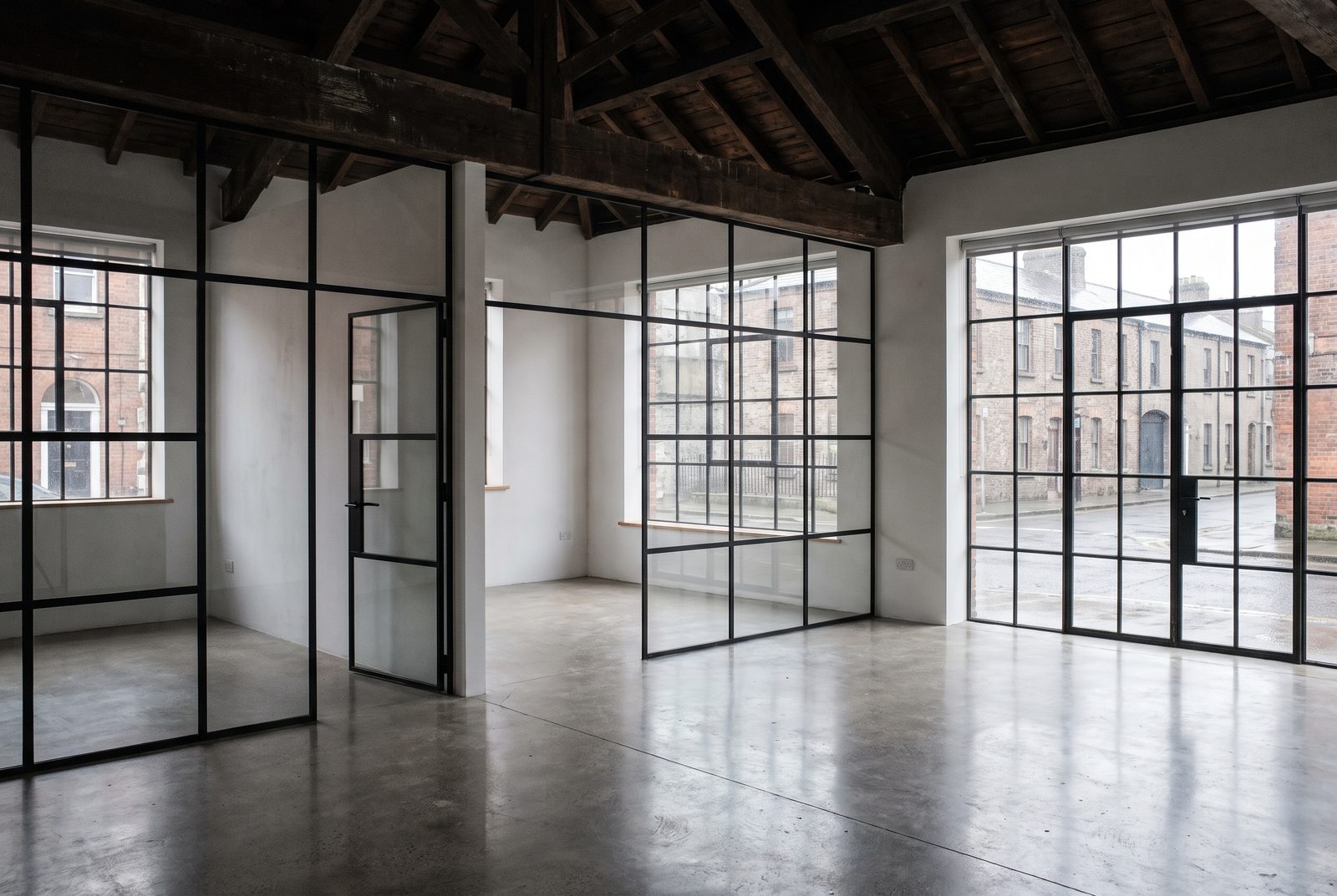 Modern studio workspace fit-out with exposed timber trusses, polished concrete and glass partitions